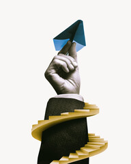 A spiral staircase next to a hand holding a paper airplane.