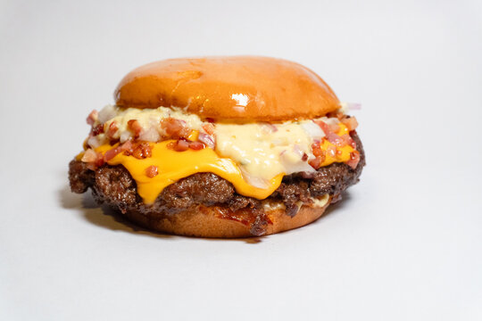 Double smash burger with signature white sauce and crispy bacon bits on a toasted brioche bun