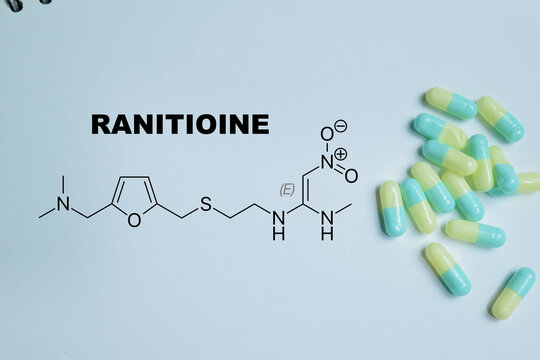 Concept of ranitidine medication write on book isolated on Wooden Table. For histamine H2 receptor antagonist drug for reducing stomach acid, acid reflux and treatment of heartburn