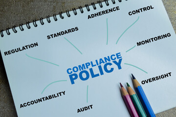 Concept of compliance policy with keywords write on book isolated on Wooden Table.