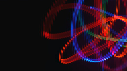 Vibrant colorful light trails swirling in dynamic motion against black background © Syedimtiaz