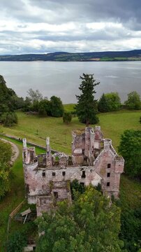 Stunning wide-angle drone footage of Redcastle, a medieval ruin in the Black Isle, Inverness, Scotland, overlooking the scenic Beauly Firth coastline.