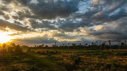  A breathtaking view of a colorful sunset over layered mountain silhouettes, with warm hues of orange, pink, and blue blending seamlessly across the sky.