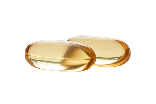 Two golden translucent softgel capsules, rich in omega-3 fatty acids or vitamin D, isolated for health and nutrition concepts