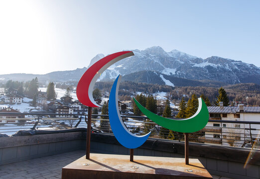 Cortina D Ampezzo, Italy - March 07, 2026: Paralympic Winter Games logo sculpture in front of snow-covered mountains and a clear blue sky, showcasing vibrant colors and a scenic backdrop