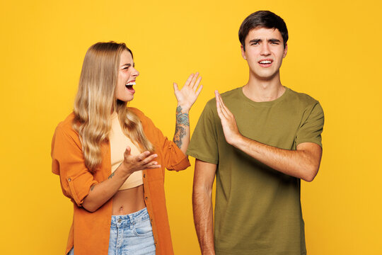 Young angry sad tired couple two friends family man woman they wear shirt casual clothes together scream shout cry isolated on pastel plain light yellow background studio portrait. Lifestyle concept.