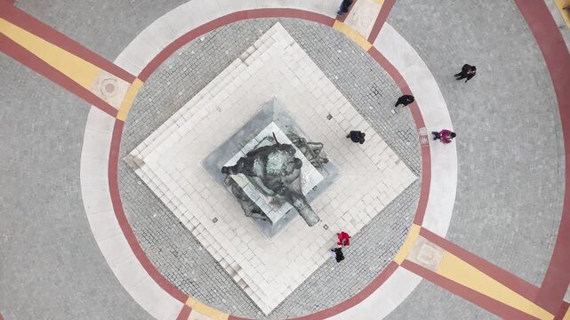 Overhead rising from the Magellan Monument to reveal the geometric patterns of Plaza Mu&ntilde;oz Gamero and the lush green trees of Punta Arenas