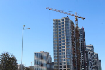 Fototapeta premium construction site with crane and building, blue sky background