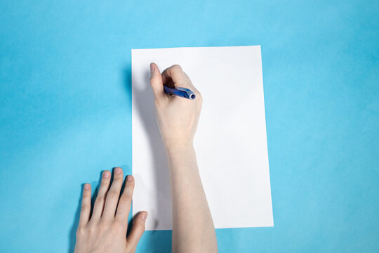 top view of hand writes on blank white paper
