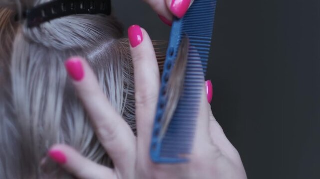 Professional hair stylist using thinning shears to cut and texturize blonde hair in a salon
