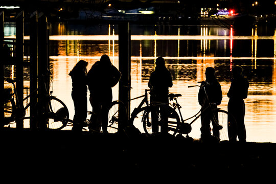 Jugendliche mit Fahrr&auml;dern abends am See