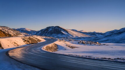 Serene winter sunrise illuminates a mountain road scenic travel through frozen highlands evokes calm beauty