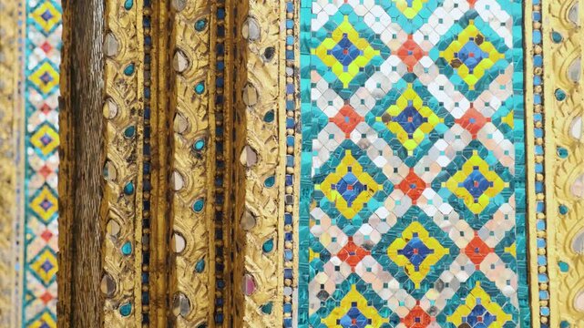 Close up of intricate mosaic tile patterns and gilded carvings from Wat Phra Kaew, Temple of the Emerald Buddha, the most sacred Buddhist temple in Bangkok, Thailand