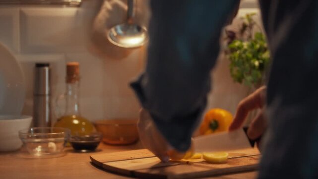 A man in a blue shirt manually peels and cuts fresh potatoes with a sharp knife, undertaking meticulous preparation work by hand, carefully removing each peel