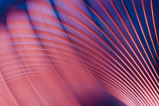 Glossy metal ribs in pink-red tones on blue backdrop, dynamic wave pattern. Modern design template for corporate slides, innovation concept, high resolution. Photo
