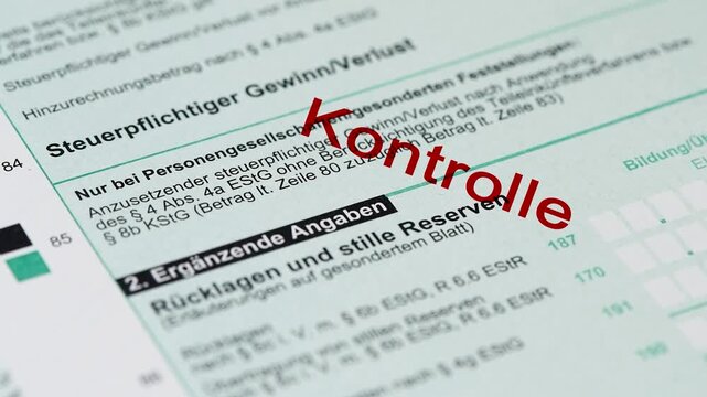Ein Formular zur Einkommensteuer wird vom Finanzamt mit einem Stempel markiert - FOTOMONTAGE