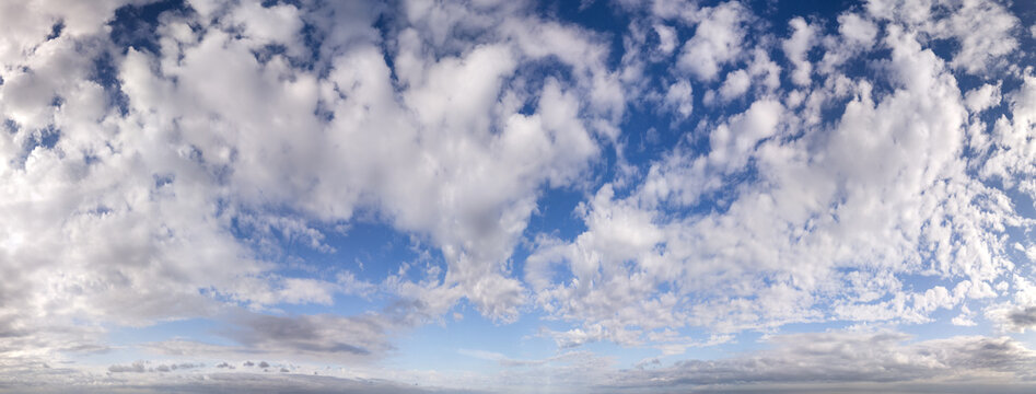 Panoramic Blue Sky Filled With Fluffy Clouds Over a Wide Distant Horizon