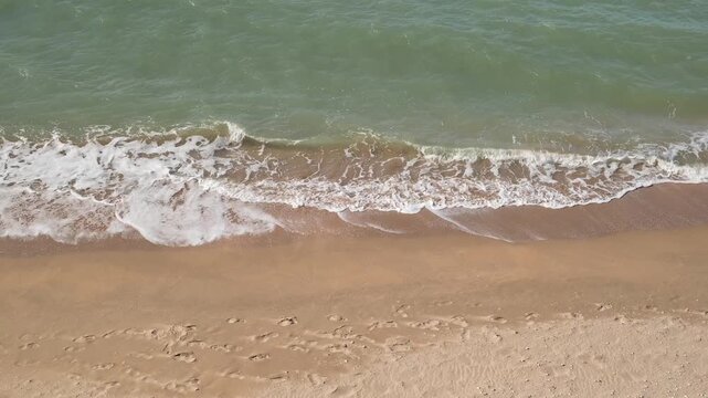 sea surf on sandy beach, top view, slow motion

