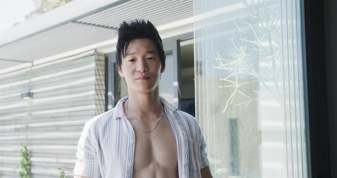 Vertical video: Man turning from profile to frontal at glass door for ads, hearing cue, smiling