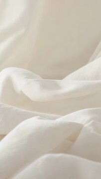 Vertical video: Panning camera revealing cream draped fabric in studio, highlighting soft folds