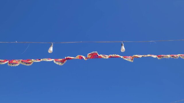 colorful holiday flags on ropes against sky, slow motion
