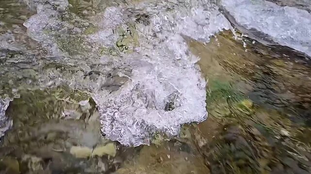 Die Wellen und Str&ouml;mung von einem kristallklaren Gebirgsbach in extremer Zeitlupe und im Detail der Wasseroberfl&auml;che