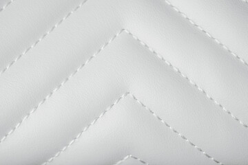 Fototapeta premium Elegant white quilted leather texture with neat chevron stitching creating a beautiful abstract pattern
