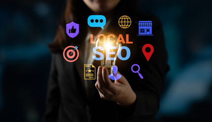 Businesswoman holds a glowing lightbulb surrounded by local SEO icons representing the importance...