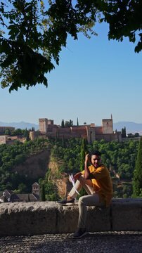 Traveler pointing at Alhambra palace in Granada Spain