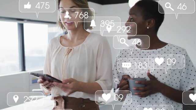 2 coworkers walking, left tapping tablet and making social icons blocking view, one holding mug