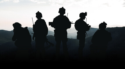 Obraz premium Military personnel stand together during conflict in Iran near mountainous area at sunset