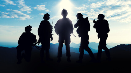 Obraz premium Military soldiers stand in silhouette during the Iran USA conflict at dusk in a mountainous area