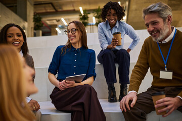 Diverse business team taking a relaxed coffee break and informal meeting in a modern lobby
