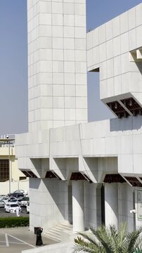 High angle view of the Mother of the Believers Aisha Mosque (Masjid Taneem) in Makkah. Features the modern white architecture, tall minaret, and the "Beginning of the Haram" boundary sign.
