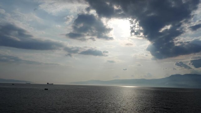 Dramatic 4K seascape time lapse: Cargo ships, moving clouds, and sun rays over the ocean. Resolution: 4K UHD (3840x2160); Frame rate: 60; Duration: 00:12; Format: High-quality HEVC (H.265) 