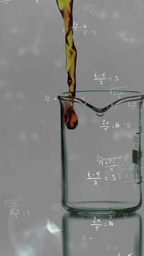 Vertical video: Amber droplet starting fall, liquid flowing into beaker, showing filling and spill