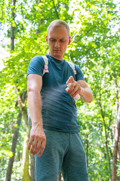 Man applying insect repellent in a forest setting