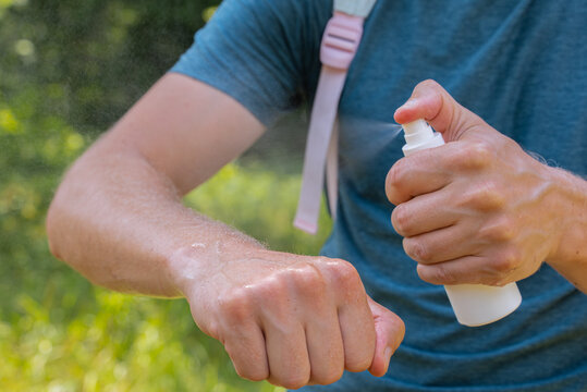 Applying insect repellent spray for skin protection