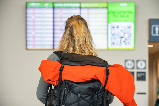 Woman at airport terminal looking at flight information