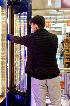 Shopper choosing items from a refrigerated section