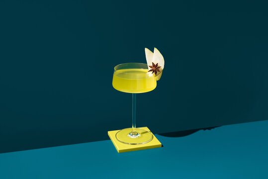 Herbal liqueur with pear slice and star anise garnish