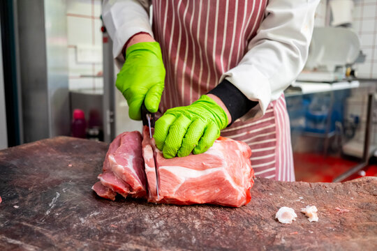 Butcher slicing fresh meat in a professional kitchen