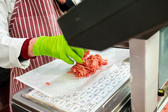 Butcher preparing ground meat at work station