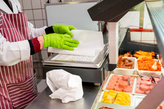 Butcher wrapping meat at counter with precision