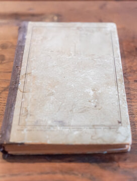 Vintage book with textured cover on wooden table