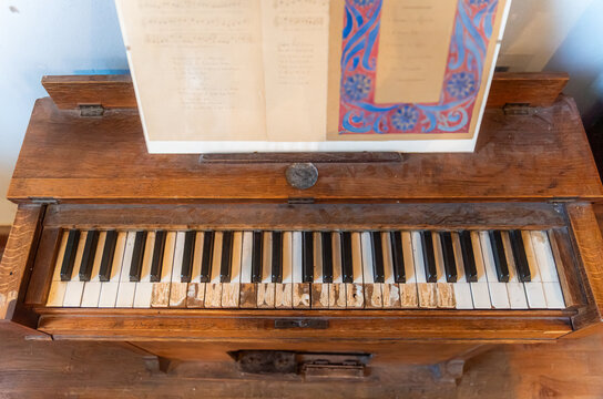 Vintage wooden piano with worn keys and sheet music