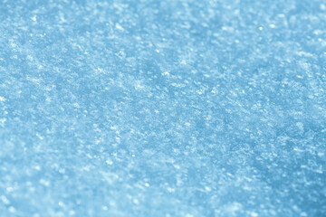 Delicate ice crystals creating a pristine, light blue texture across a frozen blanket of fresh snow, highlighting the natural beauty of winter and the intricate cold environment