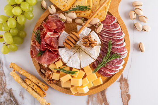 Elegant cheese and charcuterie platter with fruits and nuts