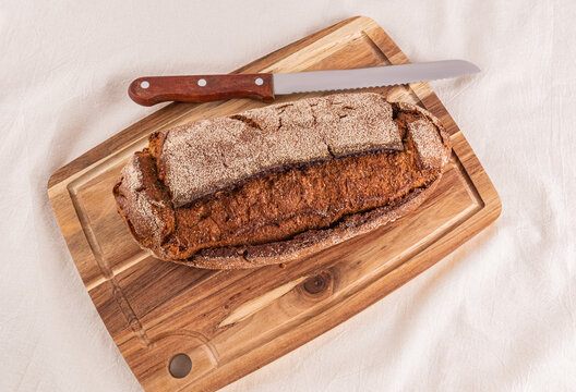 Freshly baked whole grain bread loaf on cutting board