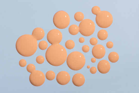 Liquid foundation drops on light background